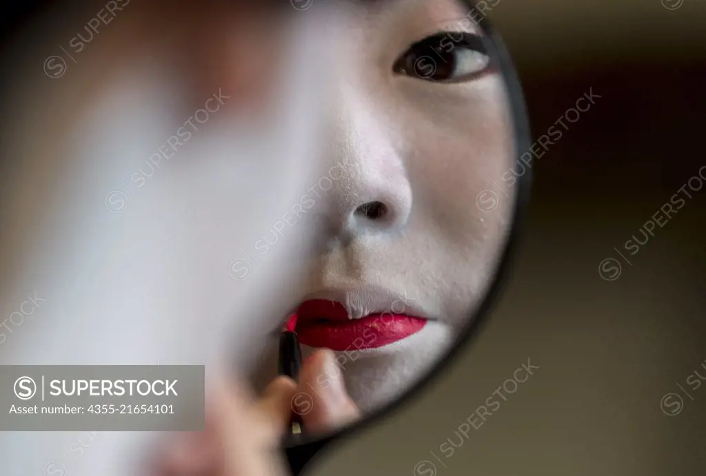 A Geisha prepares her makeup in Nara, Japan