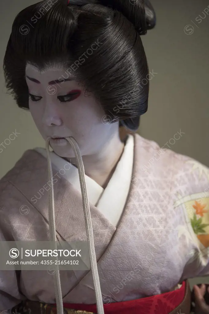 A Geisha prepares her makeup in Nara, Japan