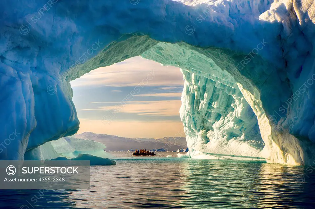 Greenland, Arched blue iceberg with nautical vessel