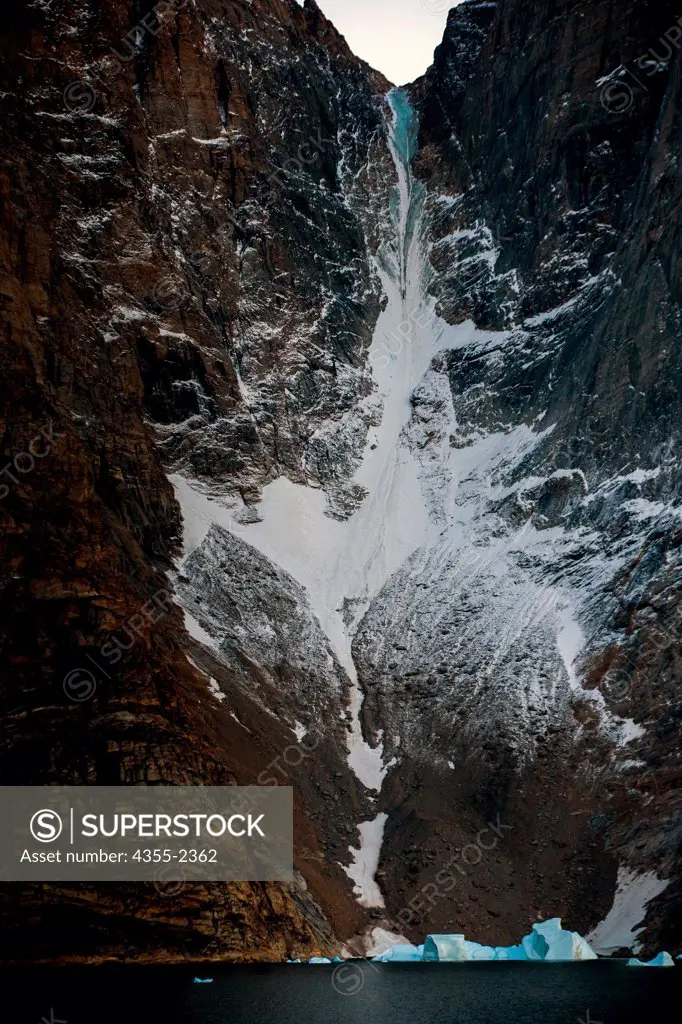 Greenland, Frozen waterfall in rocky mountains