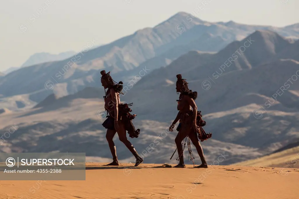 Namibia, Serra Cafema, Two Himba woman walking with mountains in background