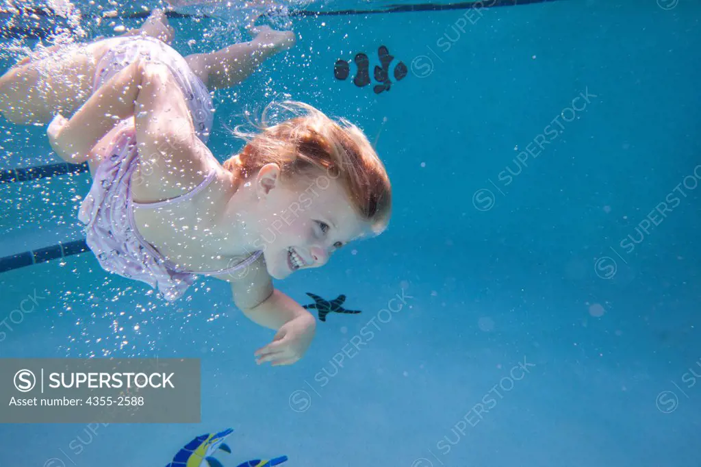 Girl diving underwater in swimming pool