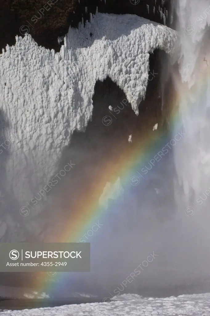 Rainbow over a frozen waterfall, Skogafoss Waterfall, Iceland