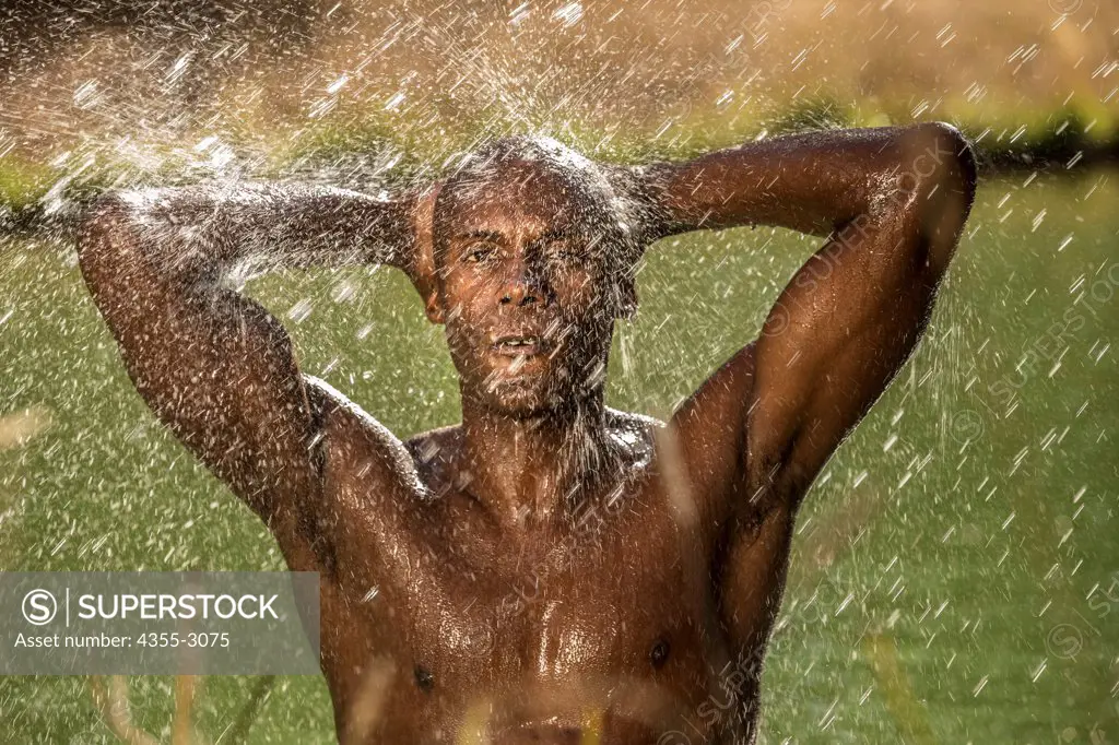 African American athlete taking a shower after a swim, Mendocino, California, USA