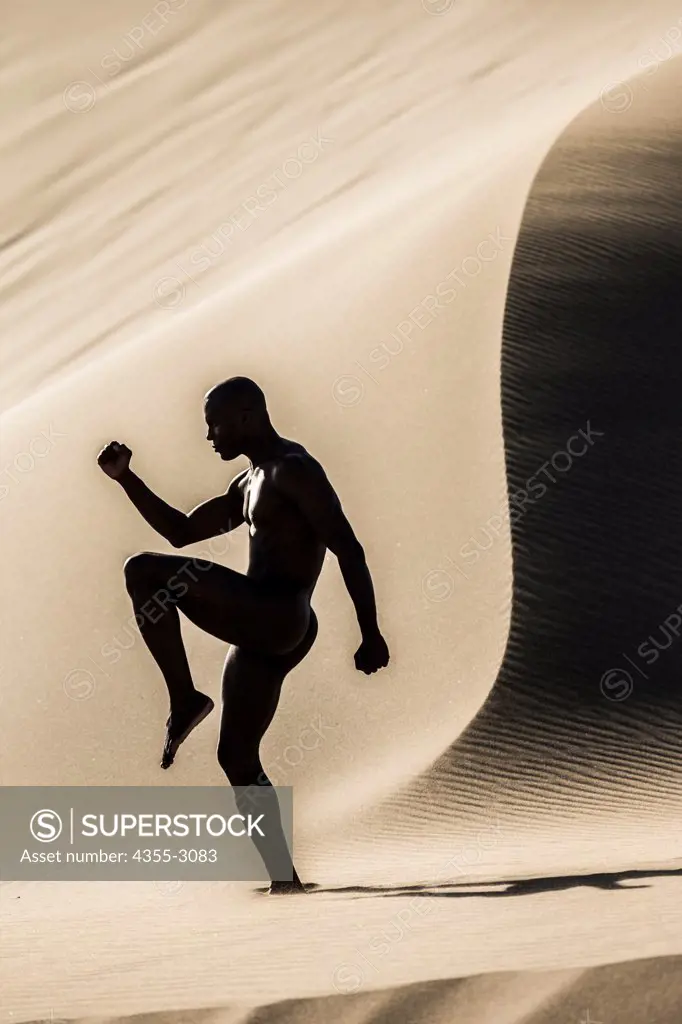 Man exercising in the dunes, Mendocino, California, USA