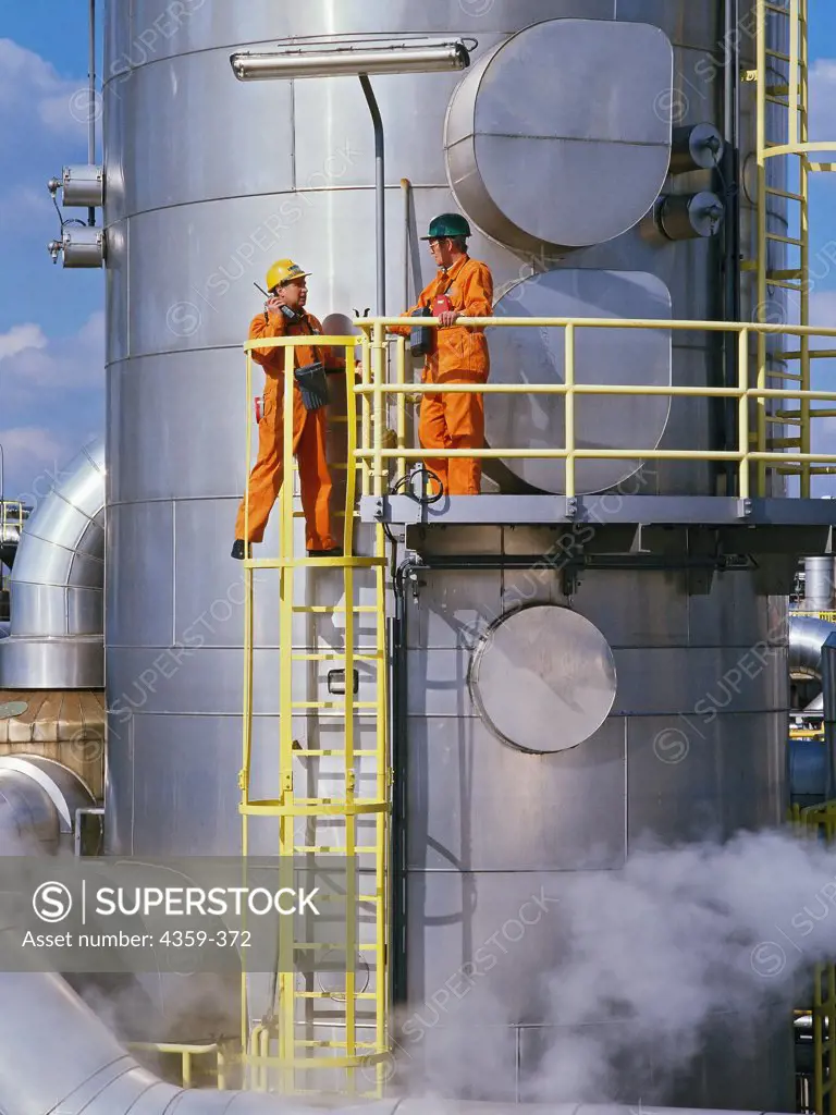 Workers measure emissions at a chemical factory.