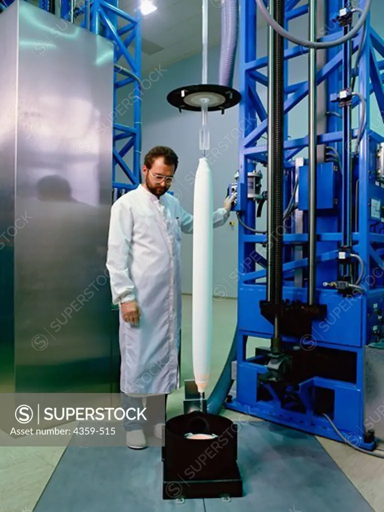 Production of glass fibers for the manufacture of fiber-optic cables. A technician feeds a blank into a sintering furnace. The fiber optic cable is produced after further production steps.