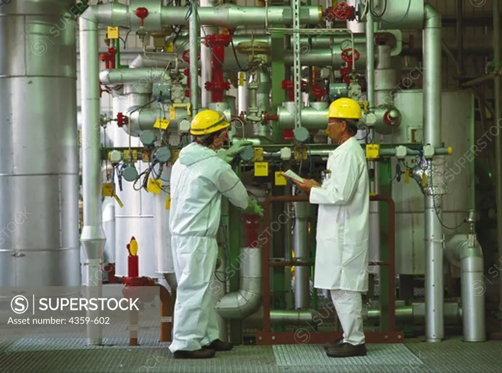 Two men inspecting chemical industrial plant