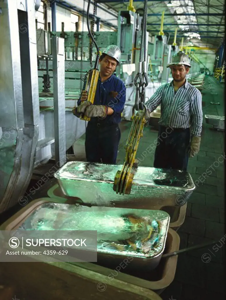 Workers taking out aluminum bars after production