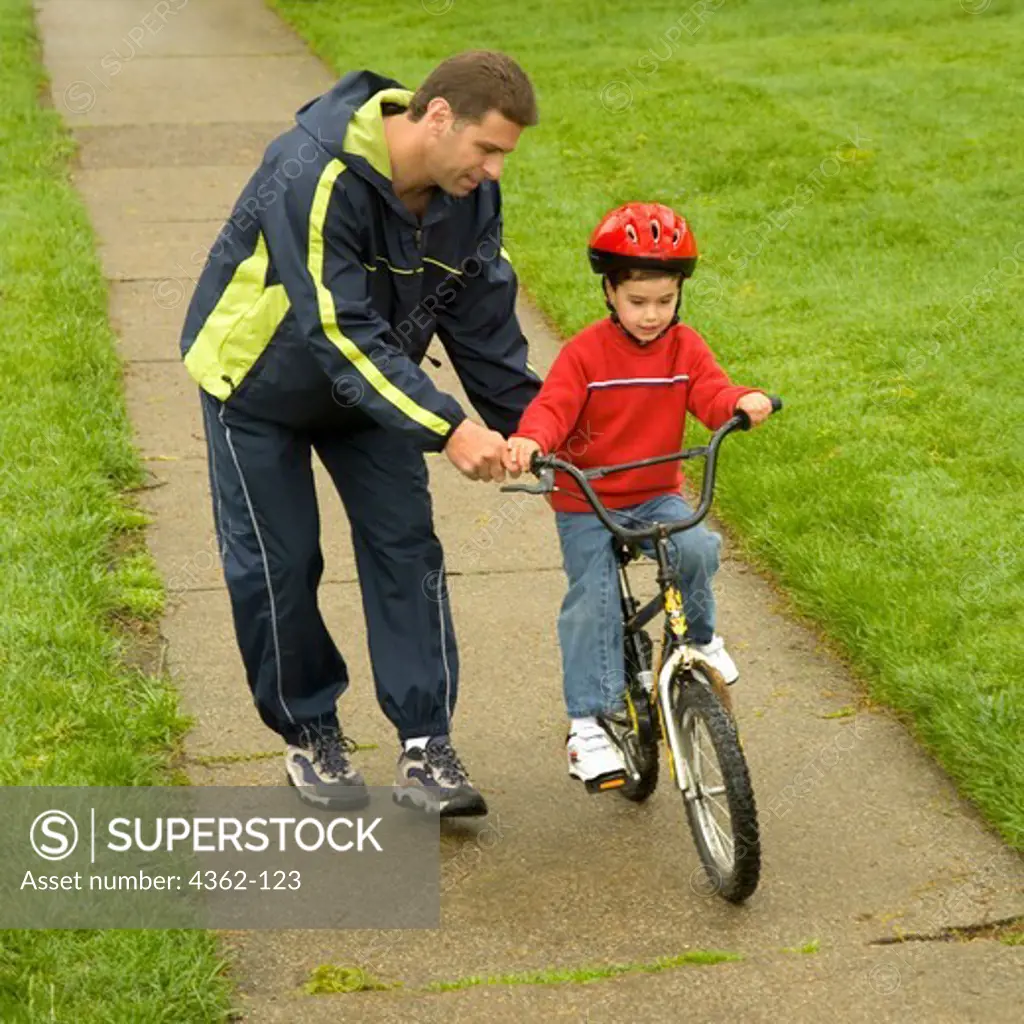 Father Helping Son Ride Bicycle