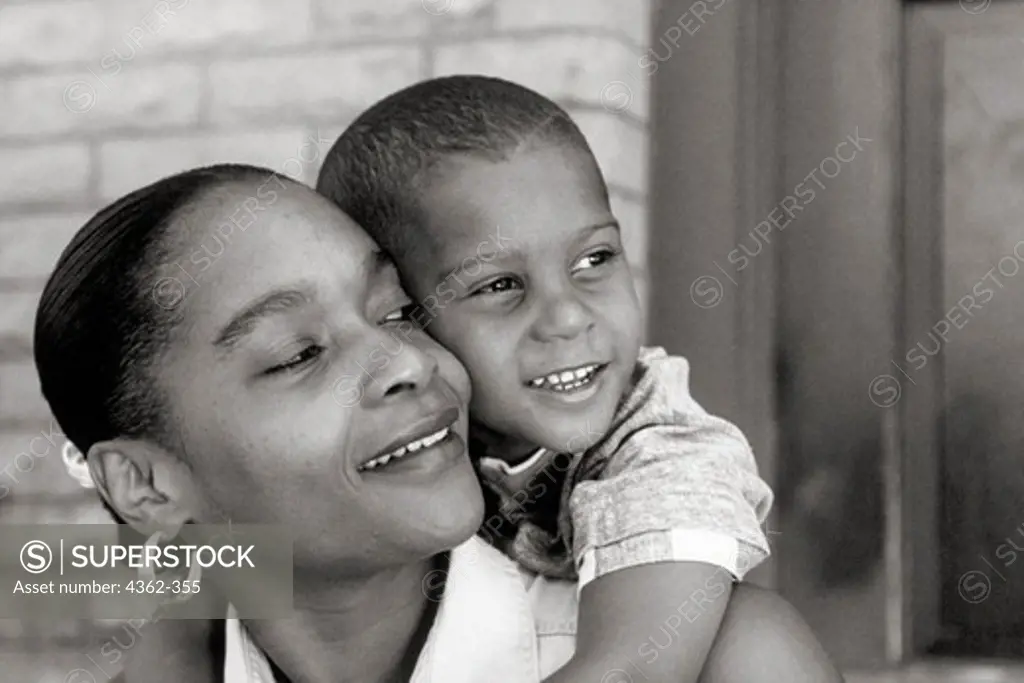 Smiling Mother Carrying Young Boy