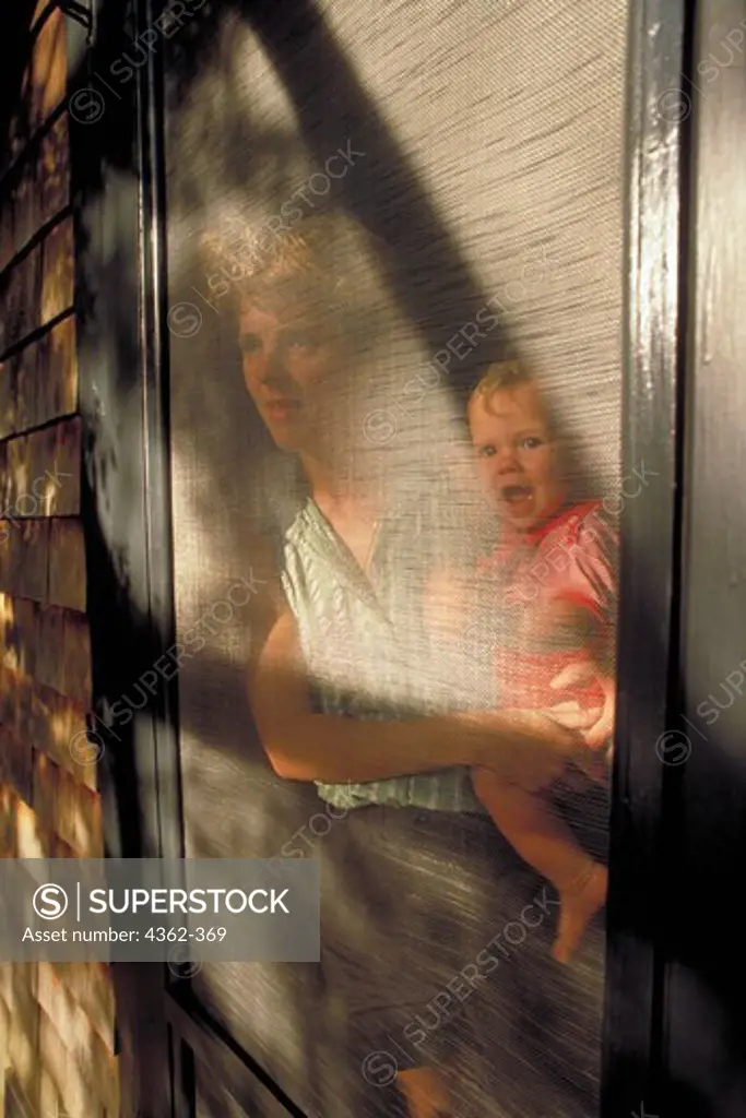 Mom and Baby Look Through Screen Door