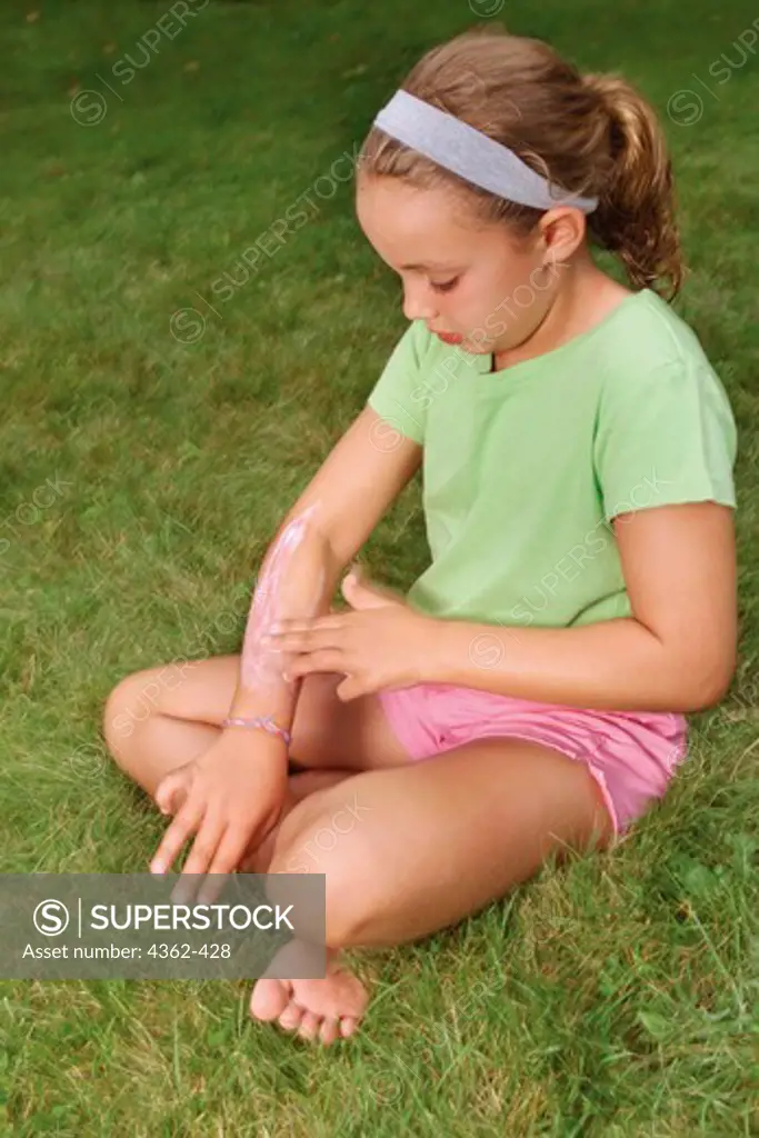 Young Girl Applies Calamine Lotion to Arm