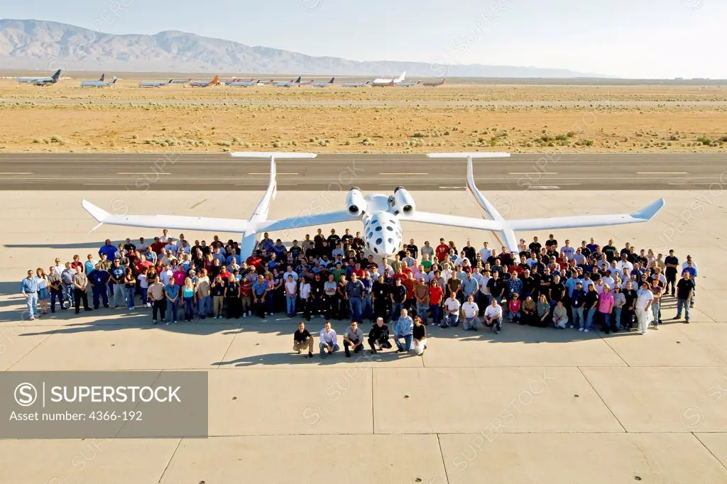 The 300+ employees of Scaled Composites gather for a group photo in front of White Knight One on the ramp at Mojave Airport in Mojave, California.  The great aircraft designer and builder Burt Rutan  stands in front of White Knight One along with some of his test pilots.