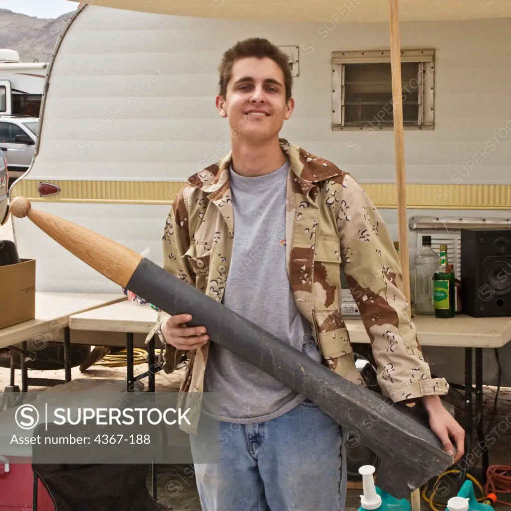 A young man at Springfest '06 holds a rocket with a wooden nosecone.