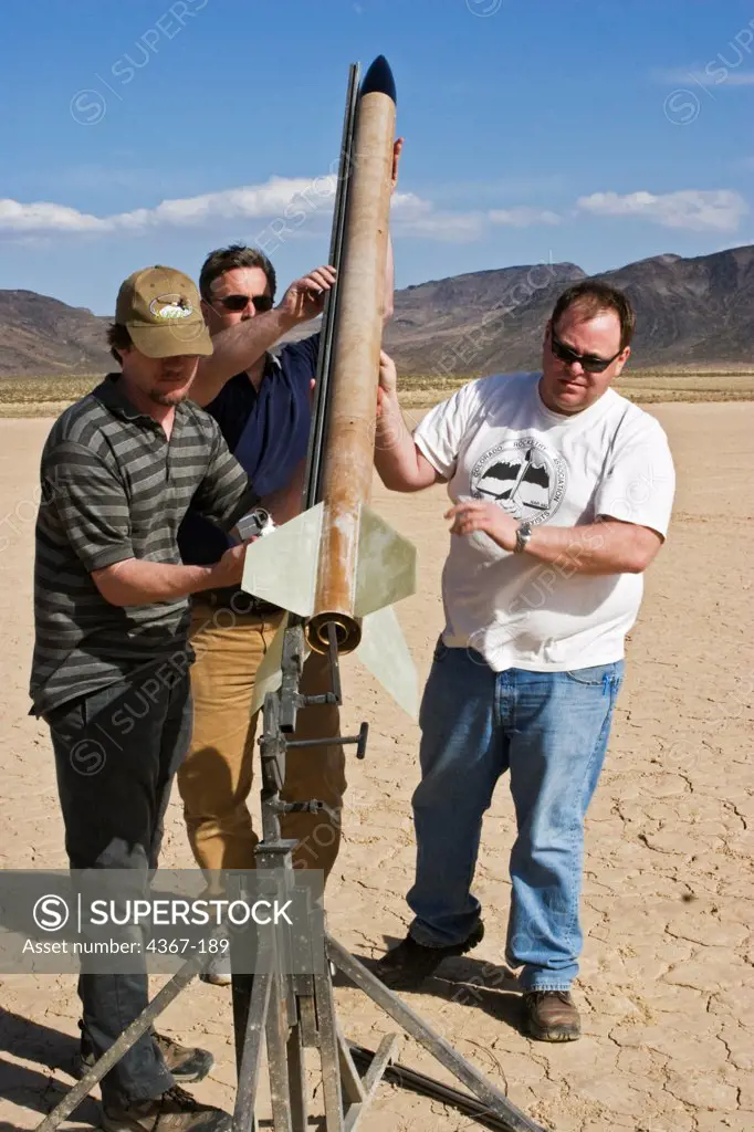 A group of men sets up a rocket for launching at Springfest '06 on Jean Dry Lake in Nevada.