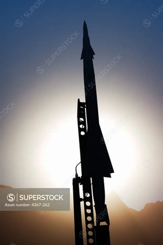A Nike Ajax missile sits on a launcher silhouetted against the Sun in the missile park outside of the museum at White Sands Missile Range in New Mexico.