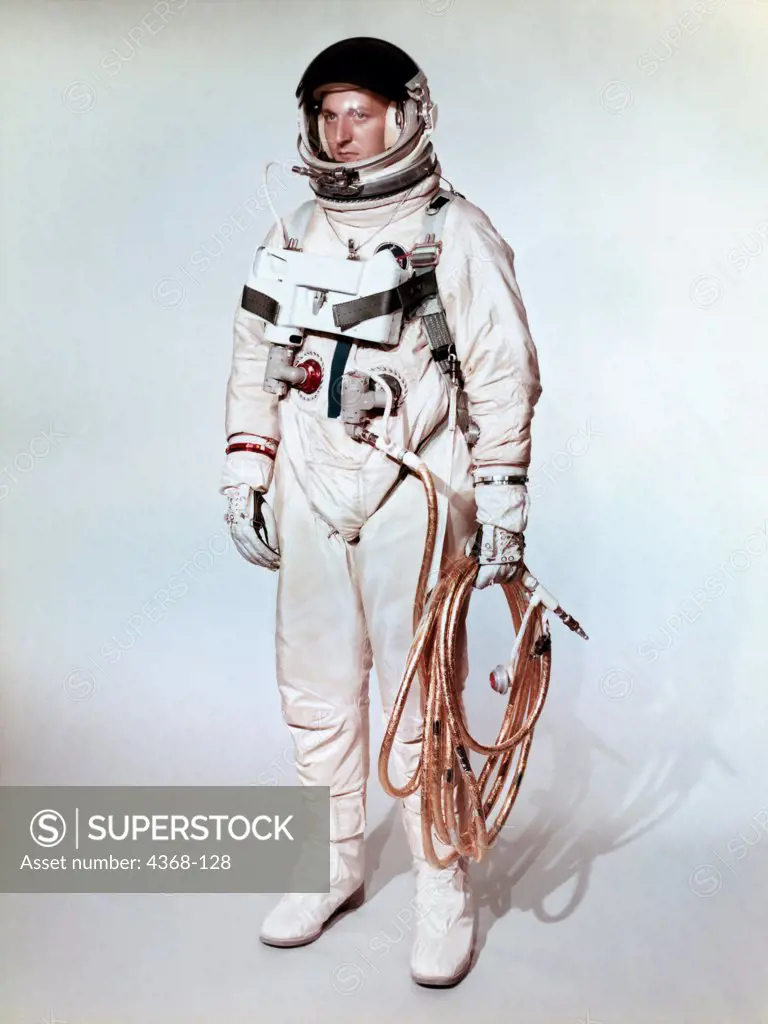Extravehicular space suite worn by a Gemini 4 astronaut is shown on a test subject.  Gold coated umbilical connects the astronaut to the Gemini spacecraft.