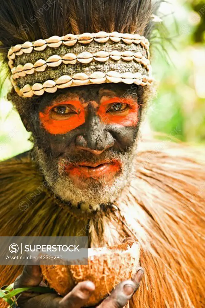 A village elder drinks coconut milk from a nut shell at a demonstration and cultural event in Tufi, Papua New Guinea. Participating clans were the Fighoya, Kandoro, Tewari, Gaboru, Safu from the villages of Koje, Kofure, Iagirua, Koave, Marabade, Fodoma, Bekoyana, Koyatona.