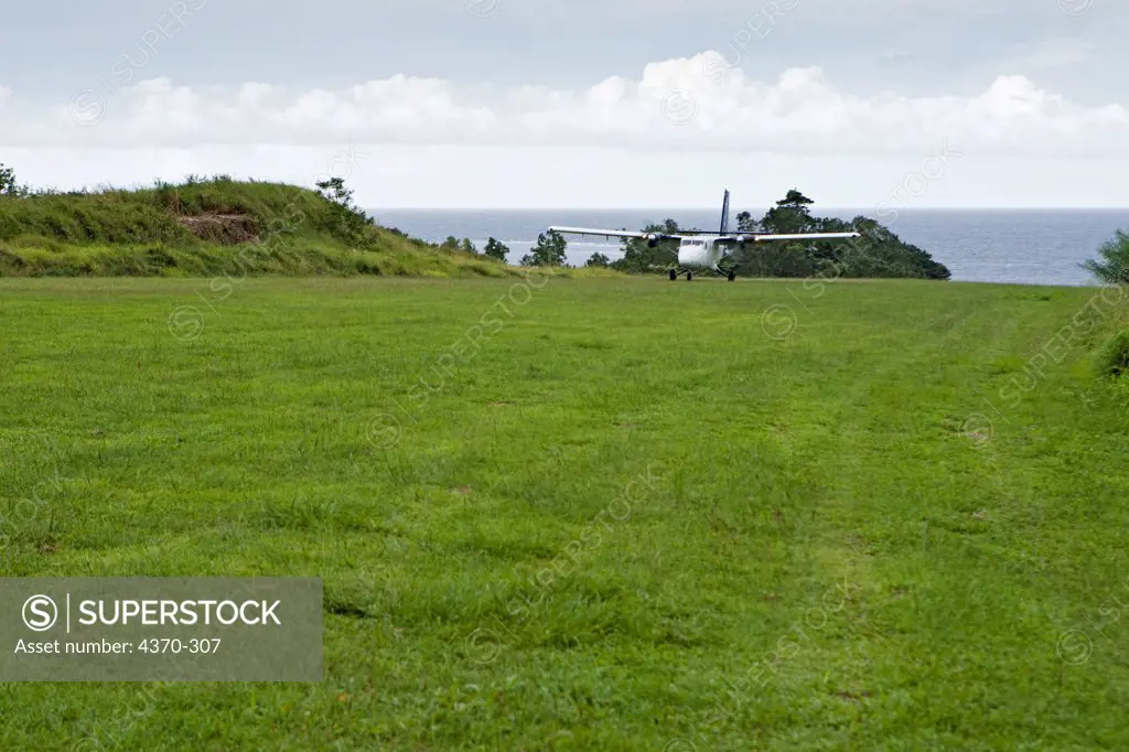 A plane lands on a grass landing strip of Oro Province, Papua New Guinea.