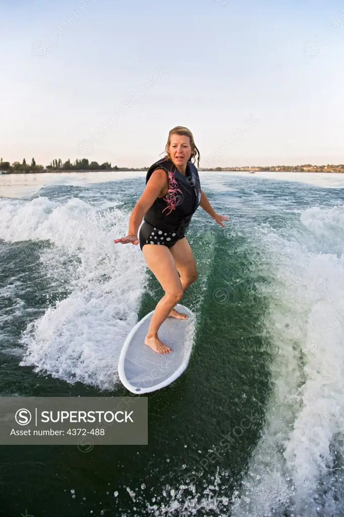 A woman surfing behind a boat (wake surfing), Moses Lake, Eastern Washington.