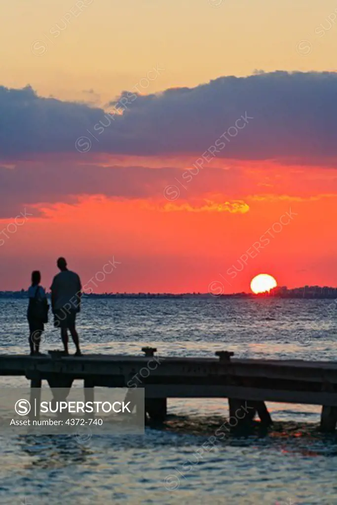 Couple watches the sun set on Isla Mujeres.