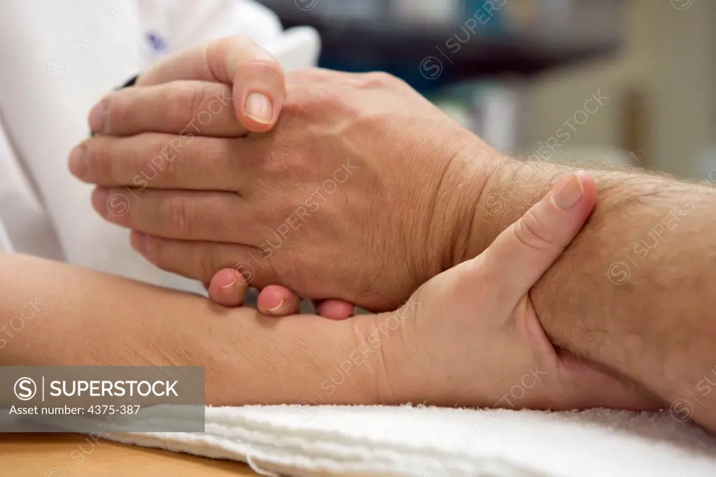 Physical Therapist Holding Hand of Patient
