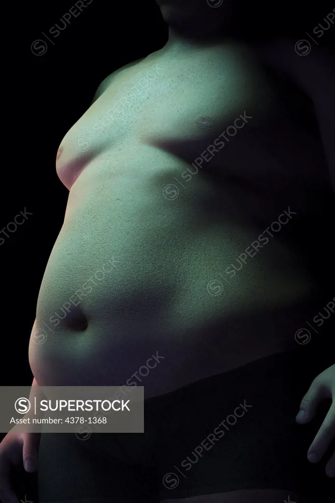 Body fat covering the stomach of an overweight man.