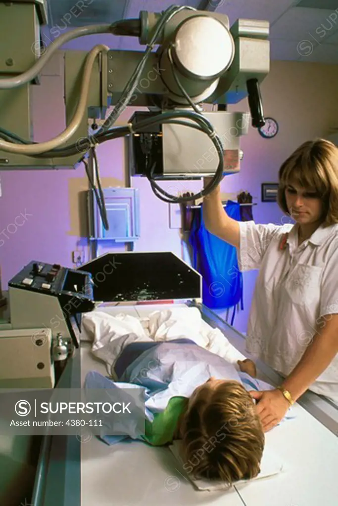 An X-Ray Technician Prepares to X-Ray a Child on a Table