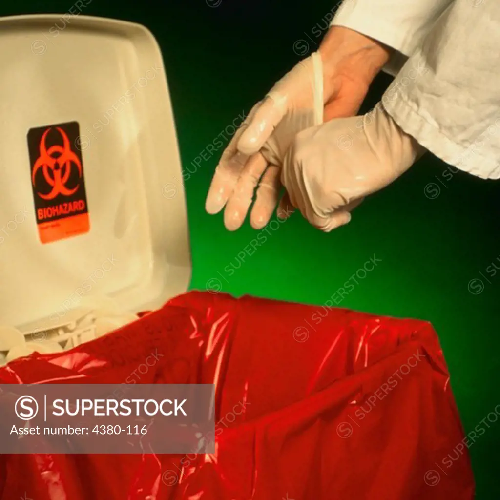 A Health Care Worker Puts Used Latex Gloves into a Biohazardous Waste Container