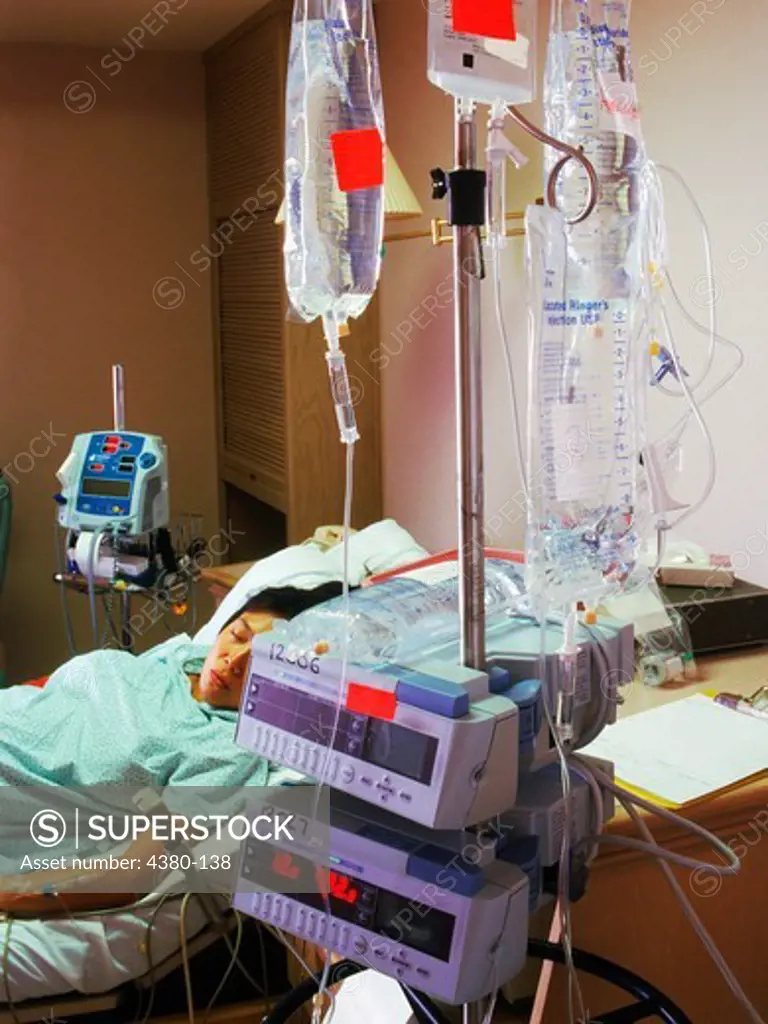 A Woman Connected to Many IVs in a Hospital Recovery Room