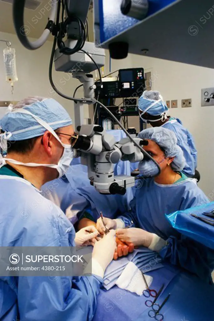 Surgical Team Using Double Microscope to Perform Carpal Tunnel Operation