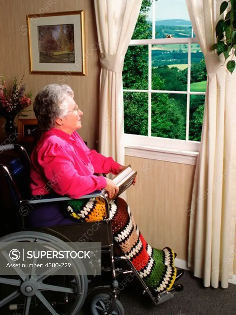 Senior woman in wheelchair looking out window