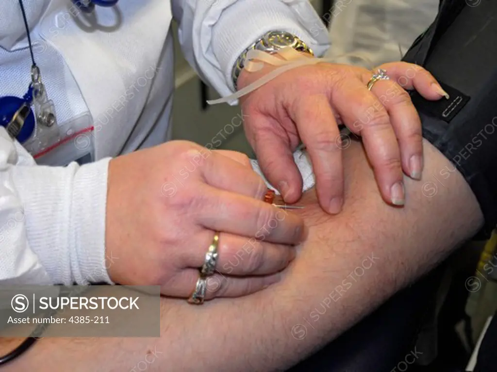 A member of the American Red Cross inserts a needle into the arm of a Coast Guardmen aboard Coast Guard Sector Jacksonville, Florida. The American Red Cross claims that only three out of every 100 Americans donate blood. (U.S. Coast Guard photo/ Petty Officer 1st Class Christopher Evanson)