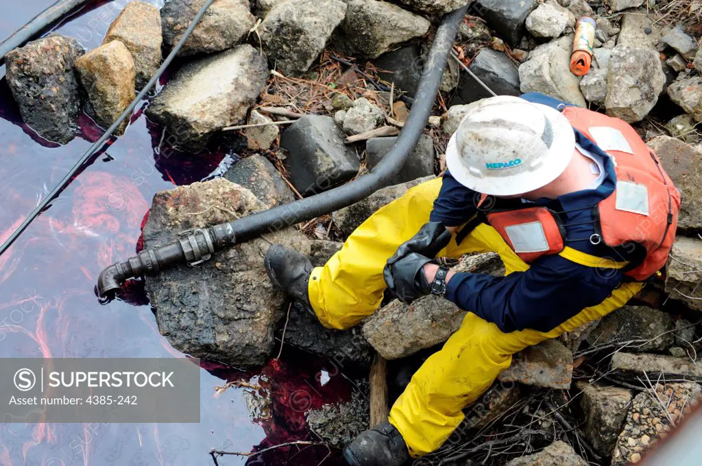 CHESAPEAKE, Va. - A HEPACO pollution response worker monitors one of the devices recovering diesel fuel spille into the intracoastal waterway after a train derailed on the A & C Canal Bridge Friday, March 26, 2010. This pipe removes fuel off of the top of the water and another device skims it from the top.