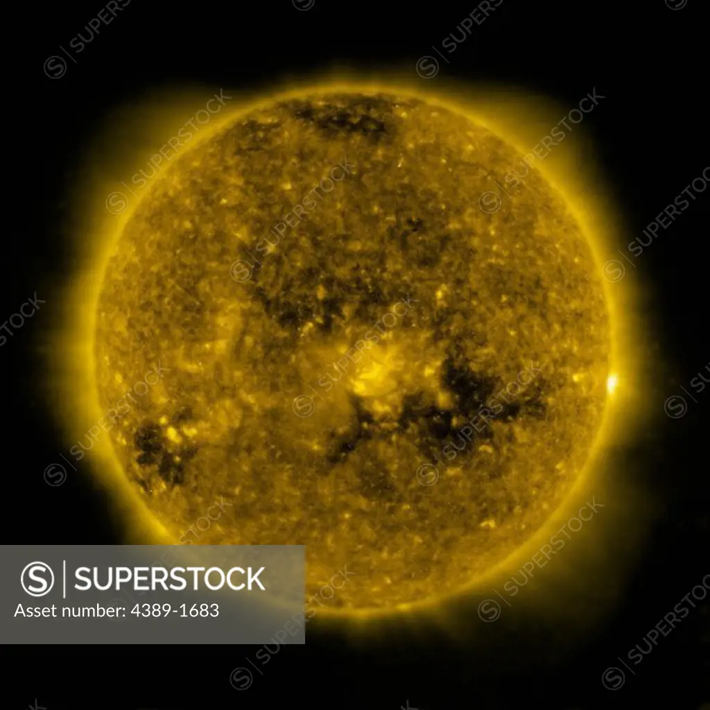 The dark coronal hole in the Sun's lower region is a 'open' magnetic area through which the solar wind follows, seen in this view from the Solar and Heliospheric Observatory (SOHO)'s Extreme ultraviolet Imaging Telescope (EIT) 284 Angstrom instrument.