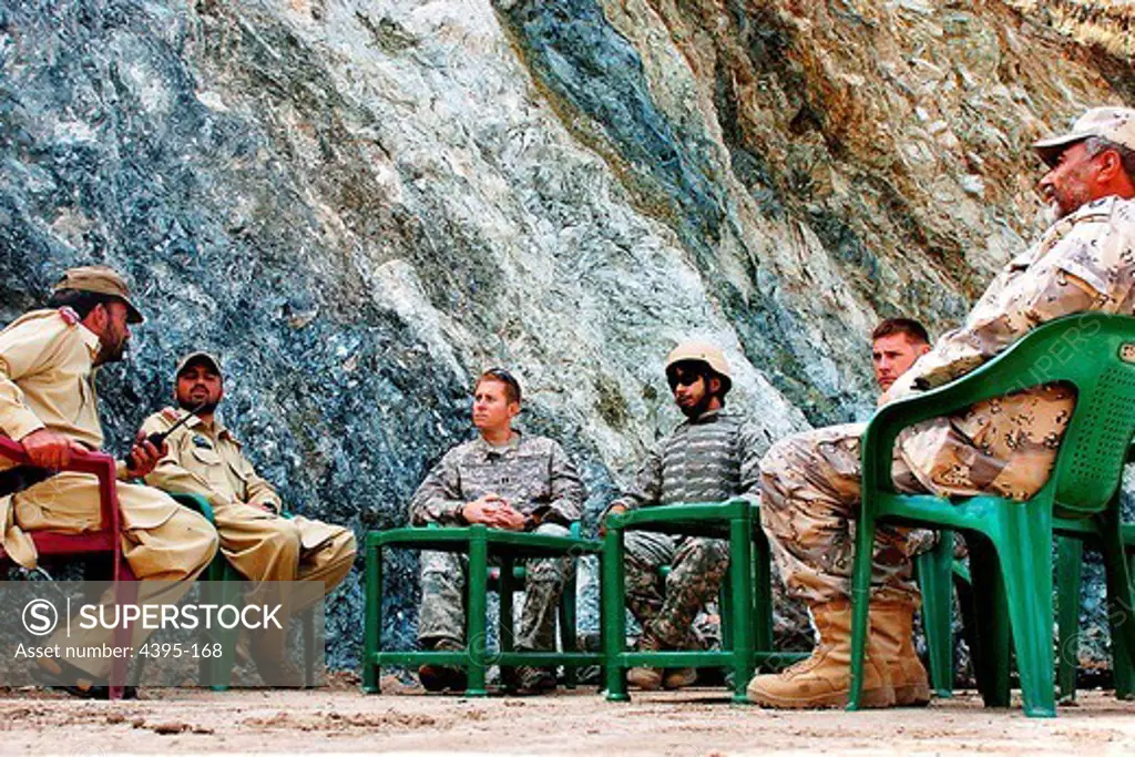 Pakistani military, Afghan Border Police and U.S. Soldiers from 1st Battalion, 32nd Infantry Regiment, 10th Mountain Division, sit side by side to discuss continued communication and security along the Nawa Pass, separating Afghanistans Kunar province and Pakistans Federally Administered Tribal Areas, during a border meeting at the high mountain pass July 5.