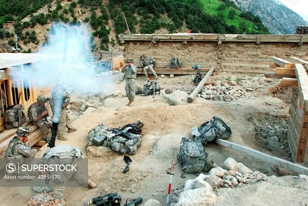 NURISTAN PROVINCE, Afghanistan - U.S. Army Soldiers with 1st Battalion, 32nd Infantry Regiment, 10th Mountain Division, fire mortar rounds at suspected Taliban fighting positions during Operation Mountain Fire, in the village of Barge Matal in eastern Nuristan province, Afghanistan, July 12.