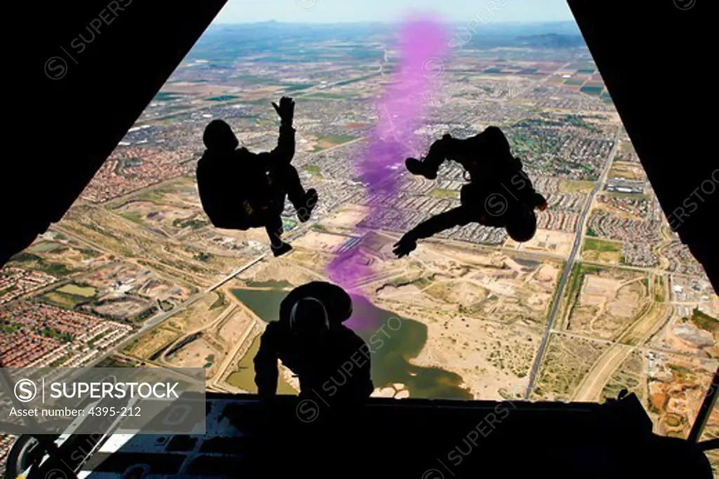 GLENDALE, Ariz. (March 29, 2010) Aircrew Survival Equipmentman 1st Class Victor Maldonado, left, Chief Special Warfare Operator Justin Gauny (SEAL), right, and Aviation Survival Equipmentman 1st Class Thomas Kinn, all assigned to the U.S. Navy parachute demonstration team, the Leap Frogs, jump from the ramp of a C-130 aircraft during the opening ceremony