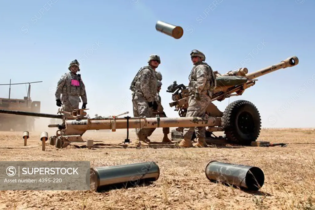 U.S. Army Pfc. Mark Ayers, 'Gun 3' Team, Alpha Battery, 1st Platoon, 2nd Battalion, 32nd Field Artillery, stands ready to dispose of spent brass during a artillery live fire qualification range on Memorial Range, Contingency Operating Base Speicher, Iraq May 21.