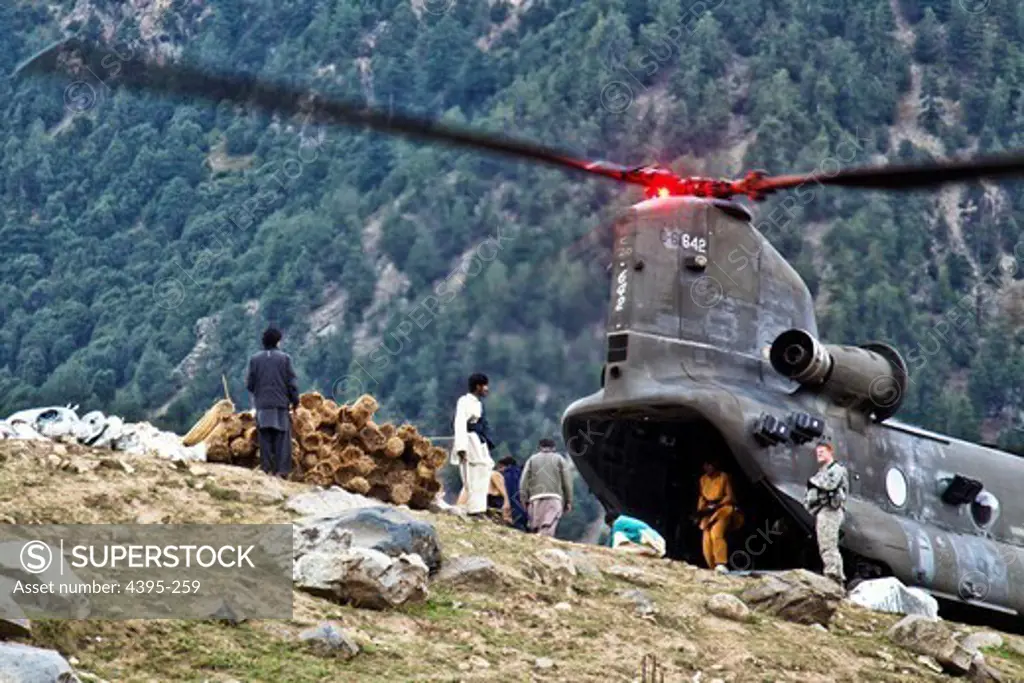 Pakistani men unload construction supplies delivered by a U.S. Army CH-47 chinook helicopter from 16th Combat Aviation Brigade to rebuild flood victims homes in Matlatan, Pakistan on Sept. 28. (Photo by: Sgt. Jason Bushong)