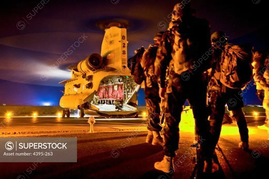 A group of Afghan Commandos, with 3rd Commando Kandak, and U.S. Special Forces Soldiers, with Special Operations Task Force - South, wait to board a CH-47 Chinook helicopter before an operation to rid insurgents from PanjwaÕi District, Oct. 15, 2010, in Kandahar Province, Afghanistan