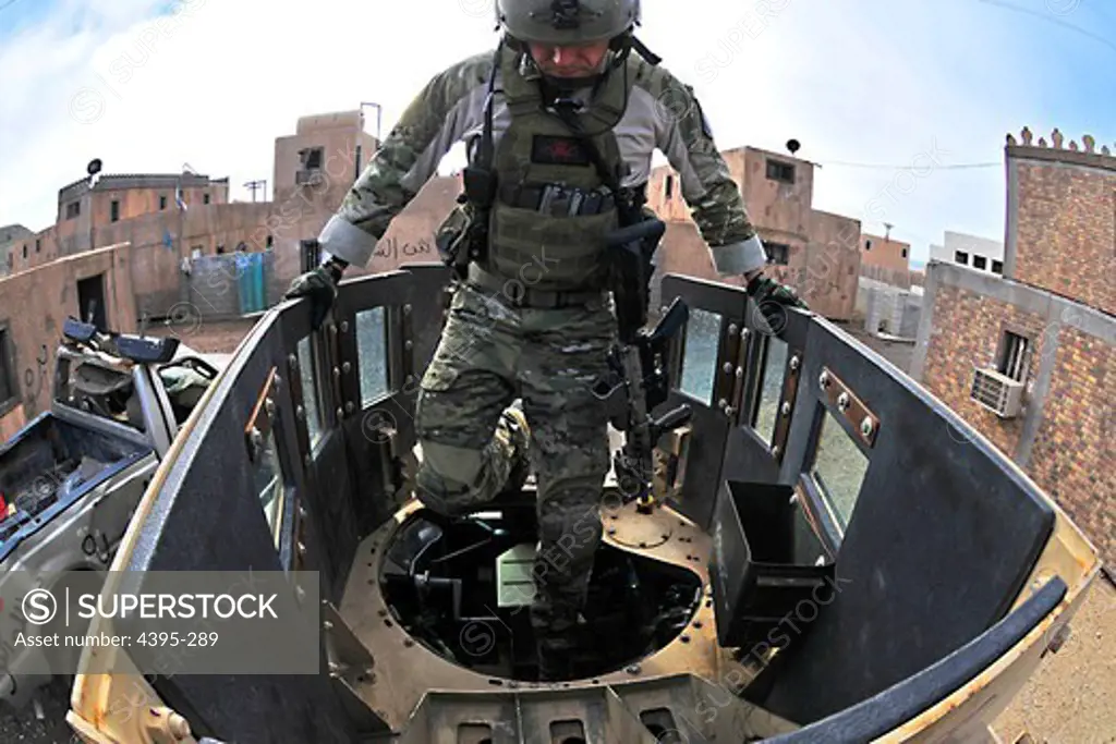 101210-N-4044H-095  SAN CLEMENTE ISLAND, Calif. (Dec. 10, 2010) A Navy special warfare specialist (SEAL) assigned to Seal Team 17, a unit comprised of both active and reserve component members based in Coronado, Calif., climbs into the turret gunner position during a mobility training exercise through a simulated city.