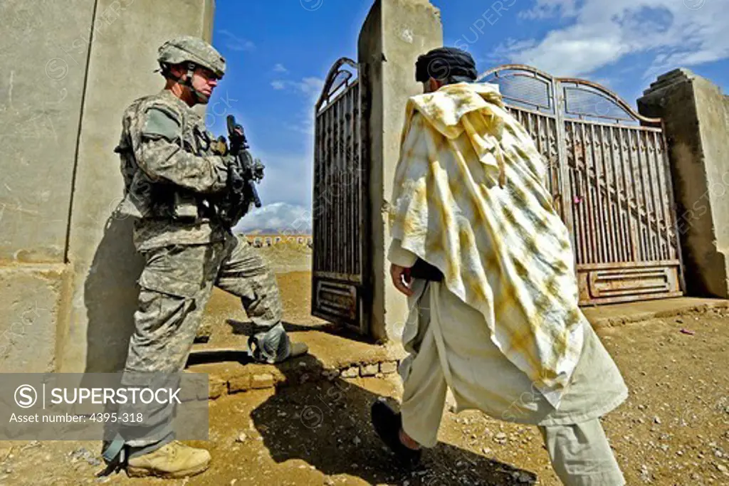 Army Staff Sgt. Will Gingras pulls security at the gate of the Shah Joy Boys School, Zabul province, Afghanistan, while engineers from Provincial Reconstruction Team Zabul inspect construction at the new school, April 9.