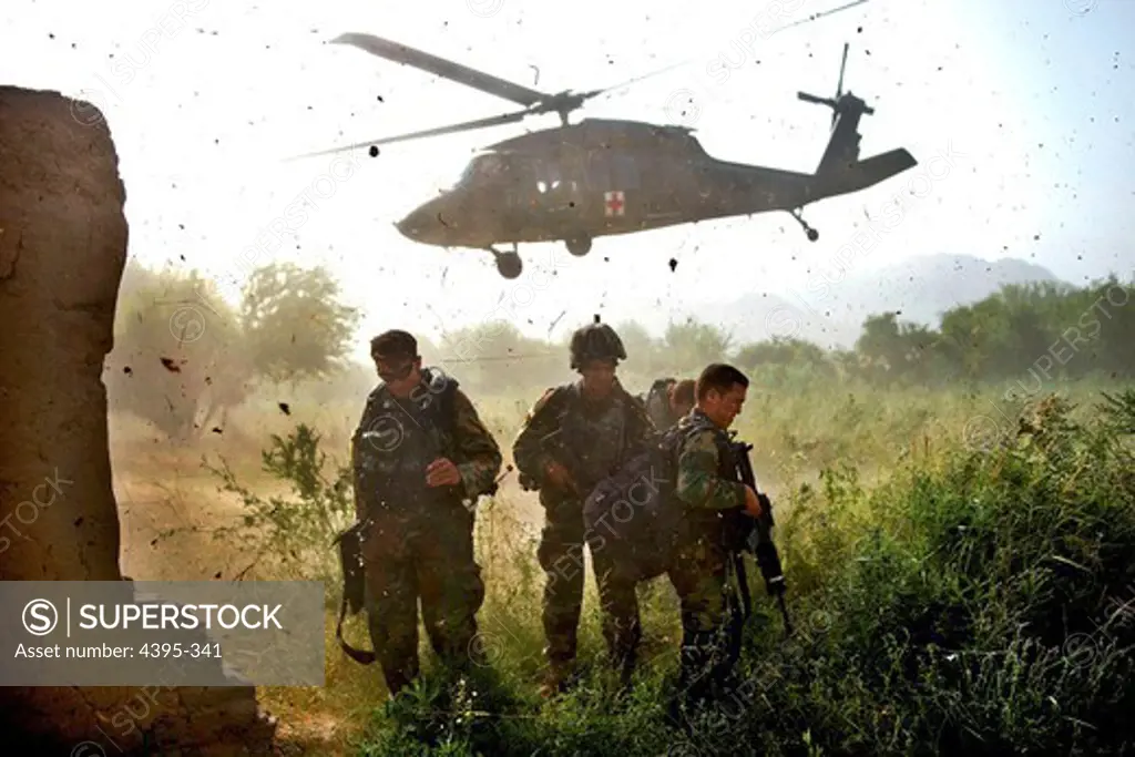 Afghan Commandos, with the Afghan National Armys 3rd Commando Kandak, shield their faces from flying debris after loading a wounded Commando on aUH-60 Blackhawk helicopter during a village clearing operation in Zhari district, July 6, 2011, Kandahar province, Afghanistan.