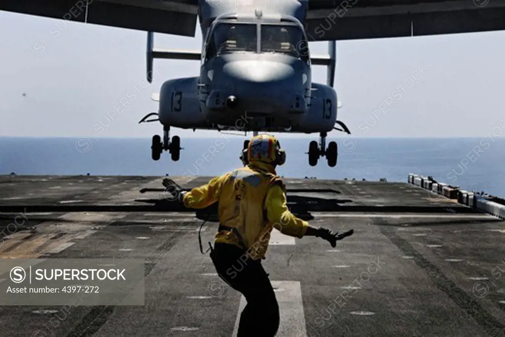 Landing Signalman Guides Osprey Onto Flight Deck