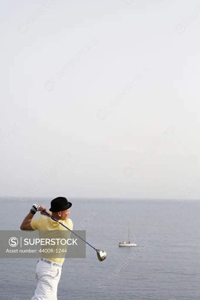A man playing golf by the sea, Gran Canaria, Spain.