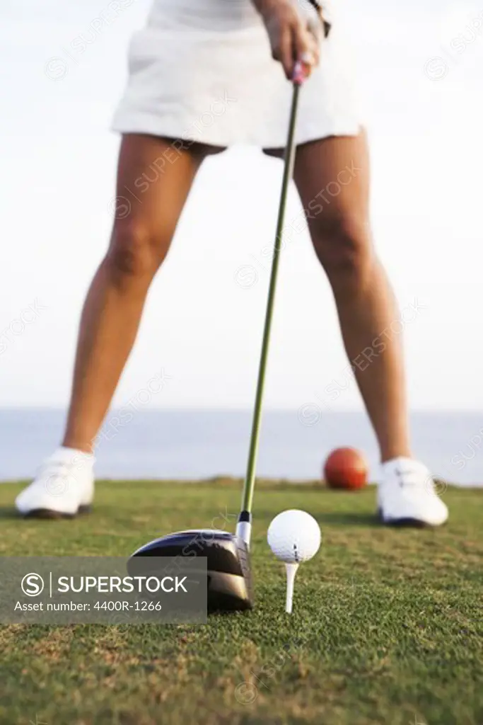 A woman playing golf by the sea, Gran Canaria, Spain.