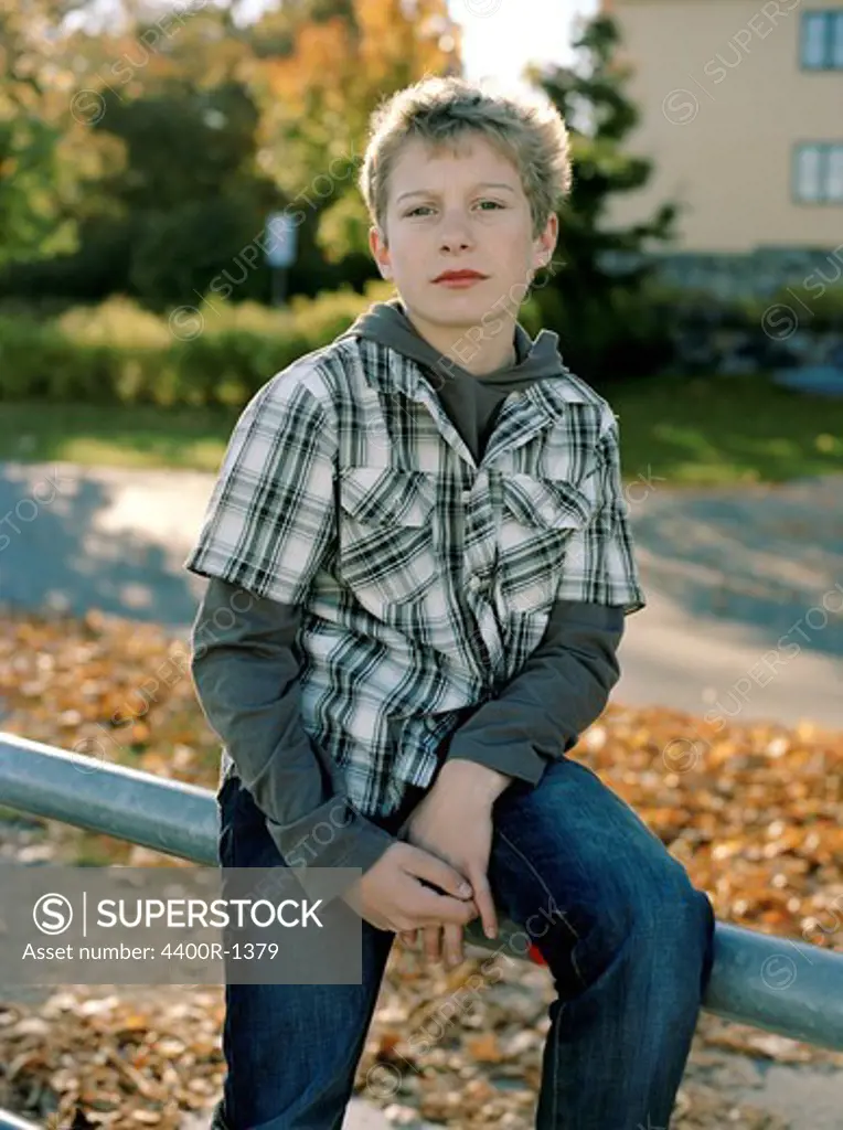 Portrait of a boy amidst autumn leaves, Sweden.