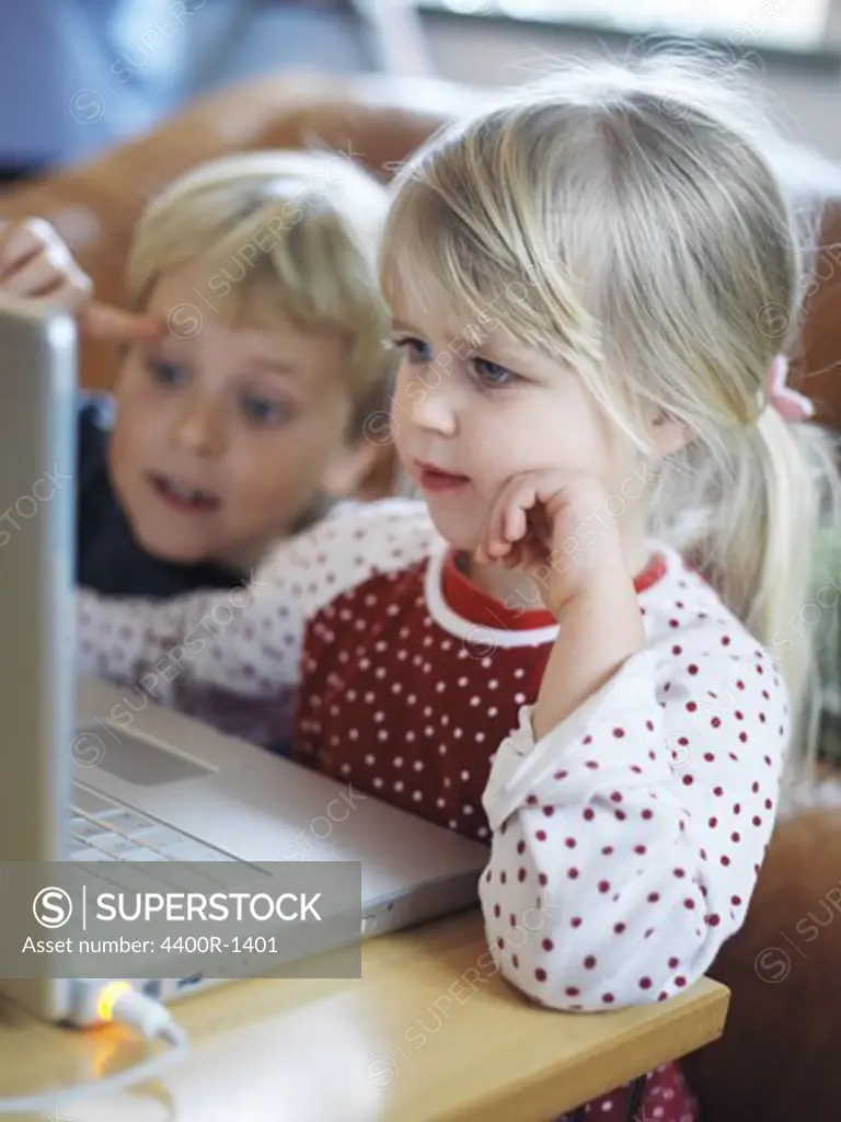 A boy and a girl in front of a computer, Sweden.